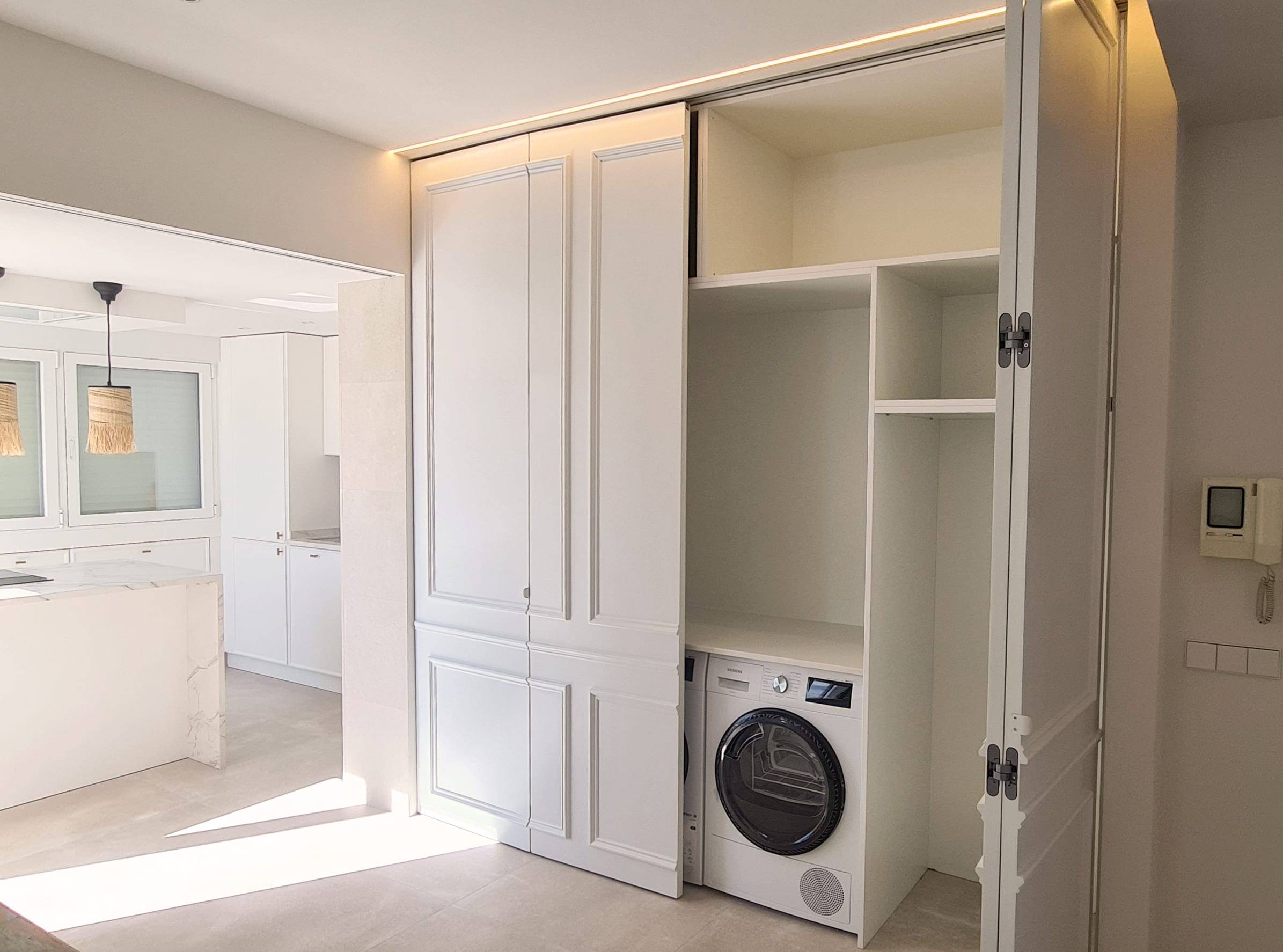 Armario empotrado que guarda la secadora y la ropa de casa junto a la cocina