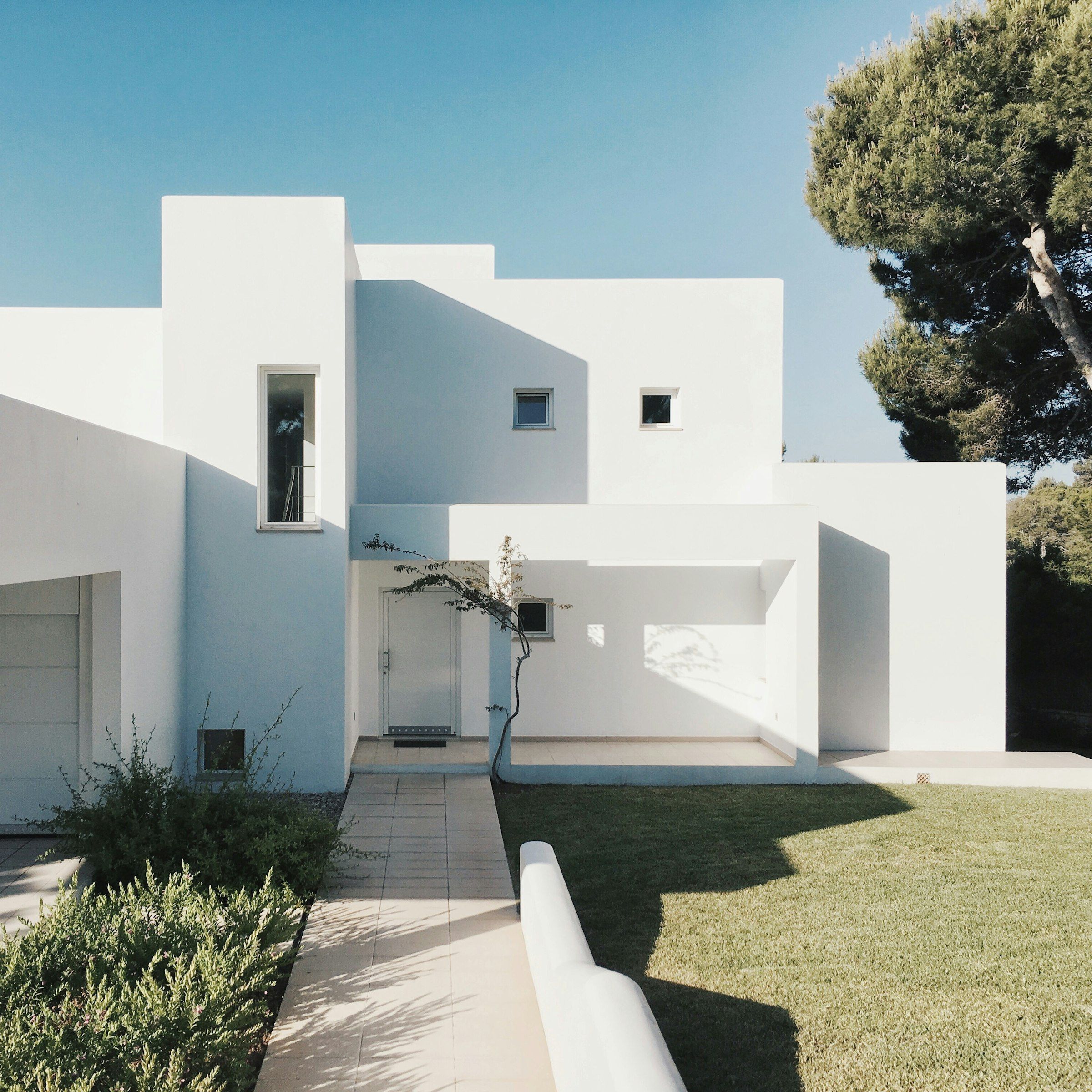 Casa moderna de fachada blanca con jardín