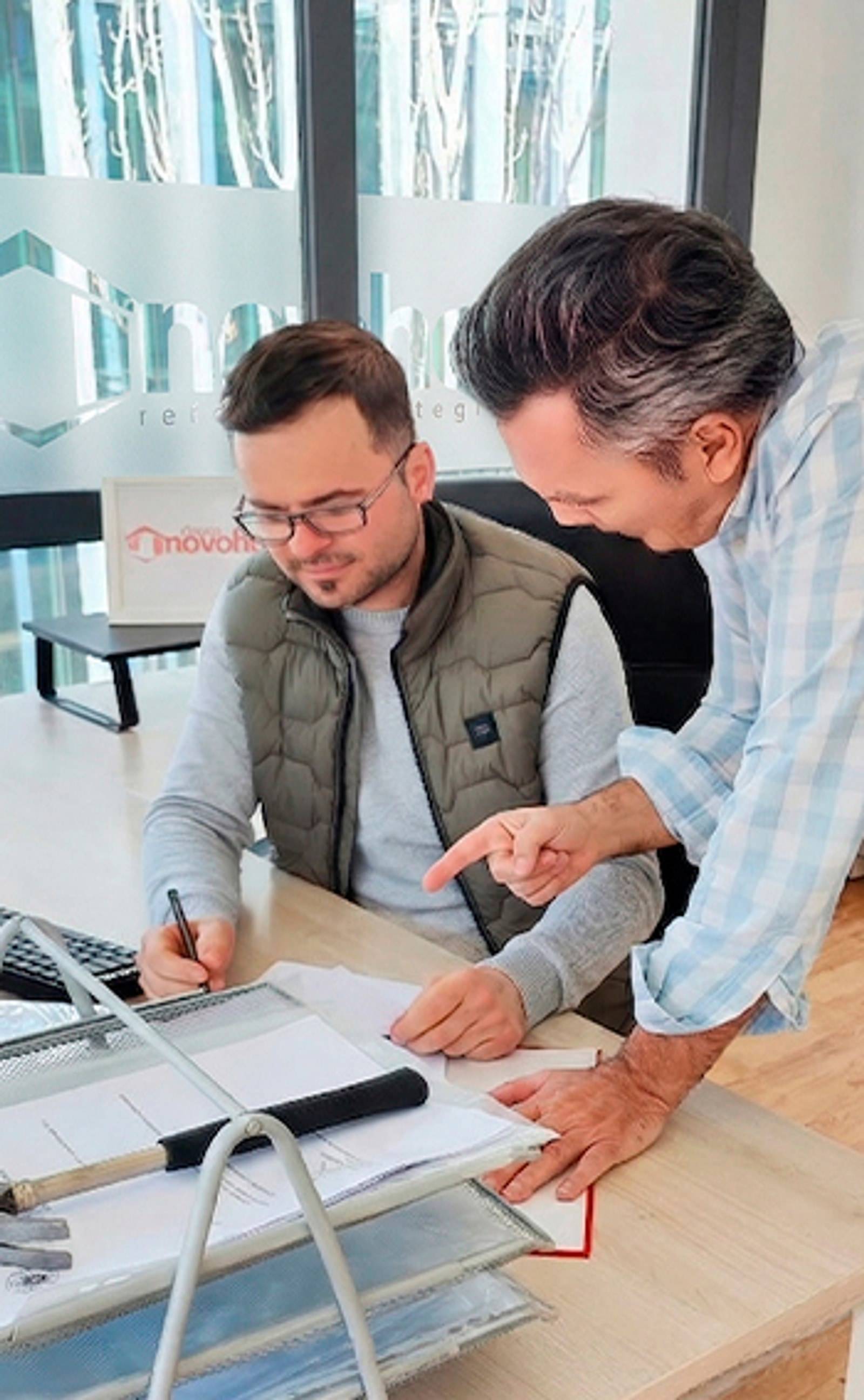 Daniel Chirica revisando unos planos con un compañero en la oficina de Novohogar
