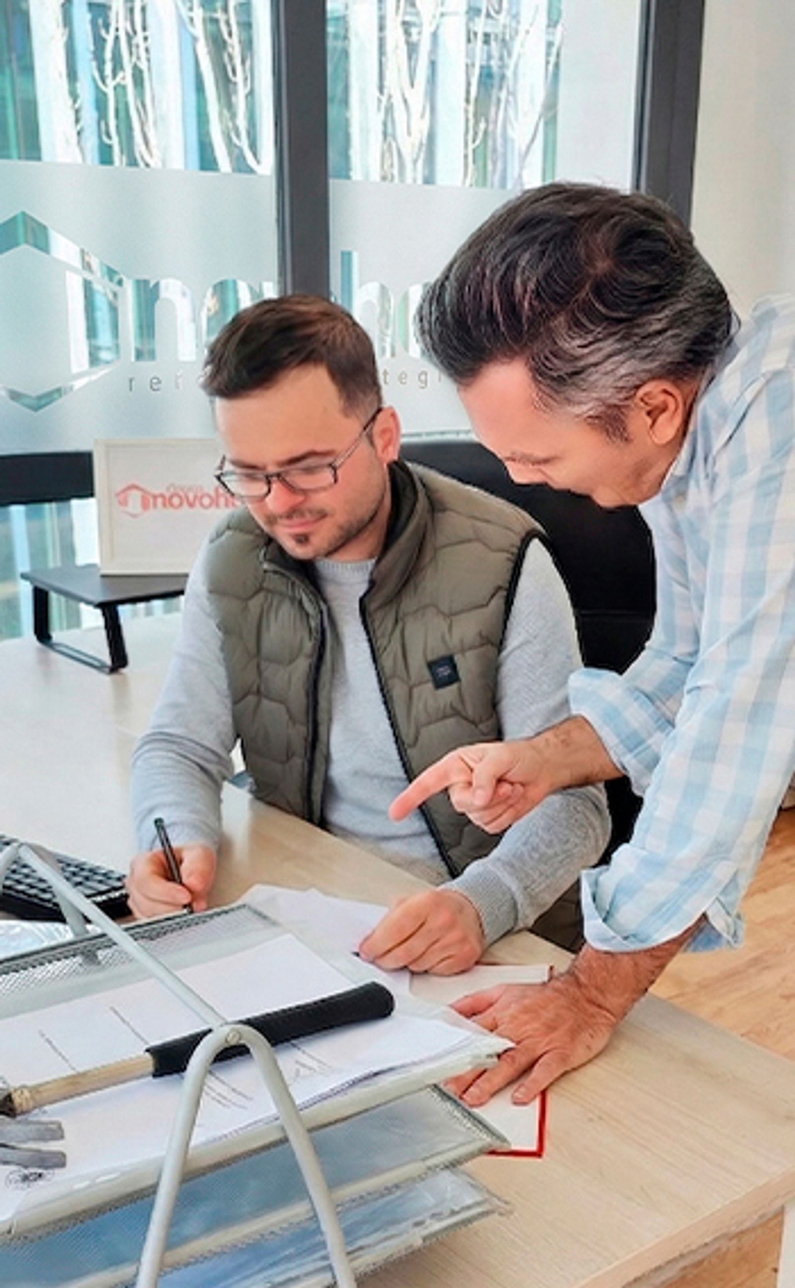 Daniel Chirica revisando unos planos con un compañero en la oficina de Novohogar