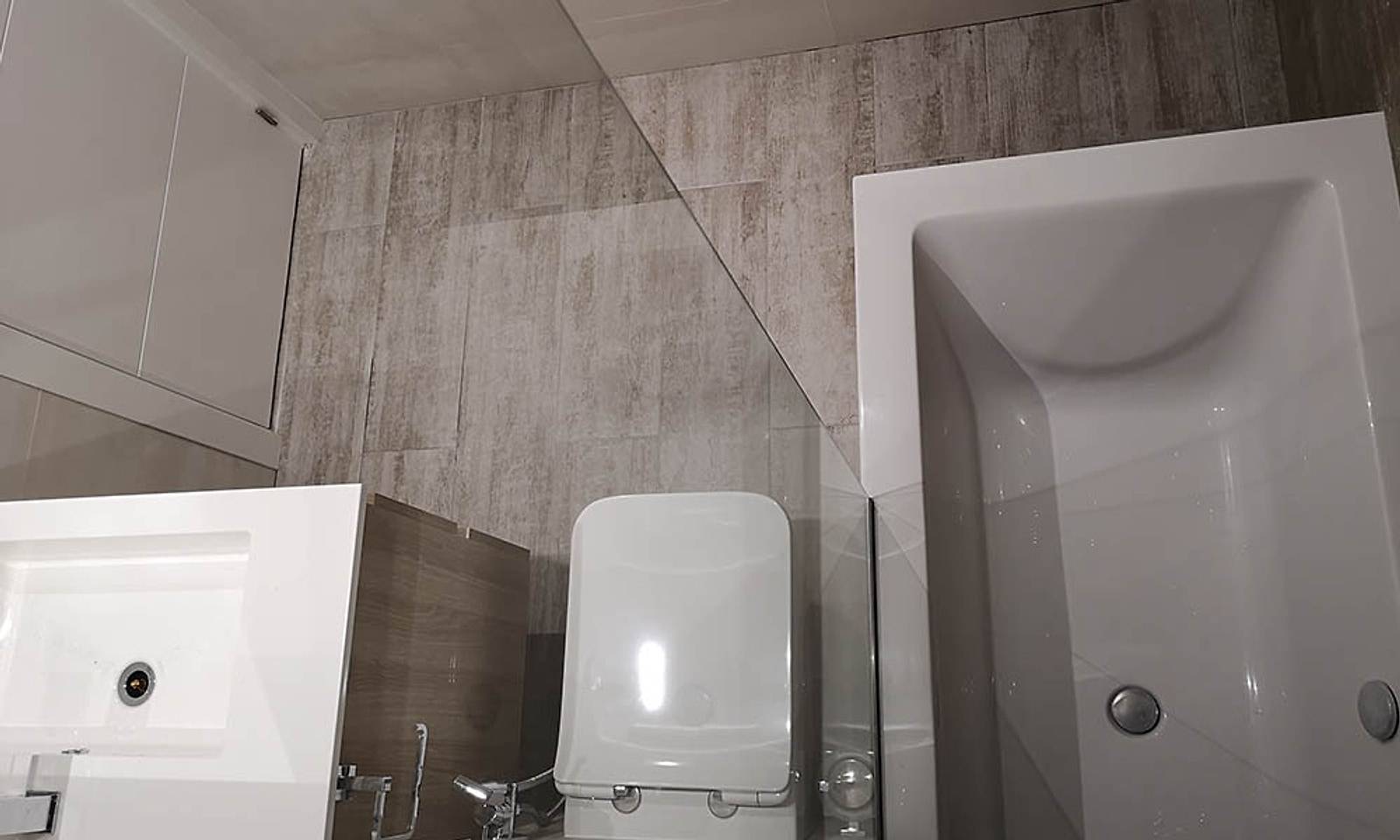 Baño del loft con bañera, inodoro suspendido y lavabo sobre mueble de madera