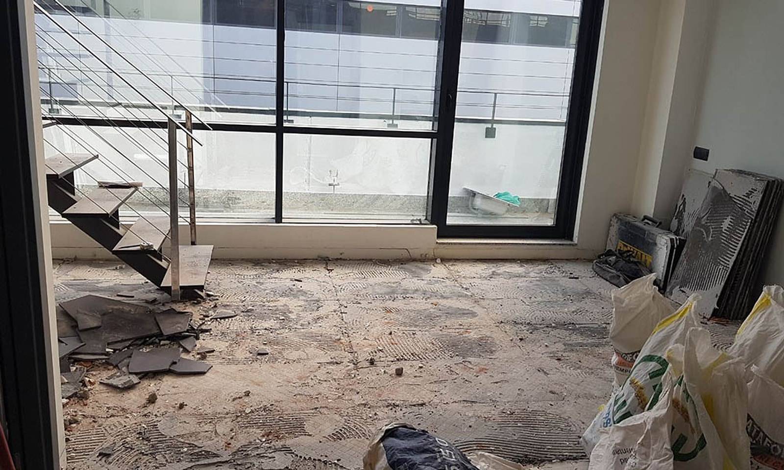 Planta baja del loft en obra, con el suelo levantado junto al ventanal