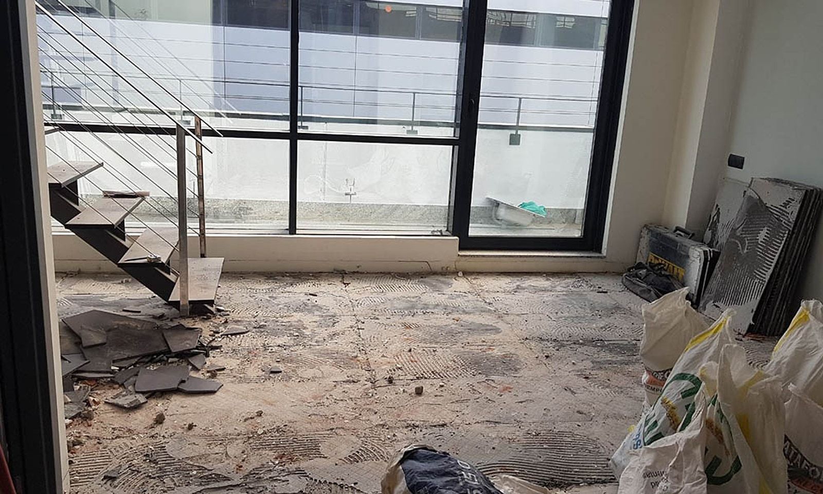 Planta baja del loft en obra, con el suelo levantado junto al ventanal