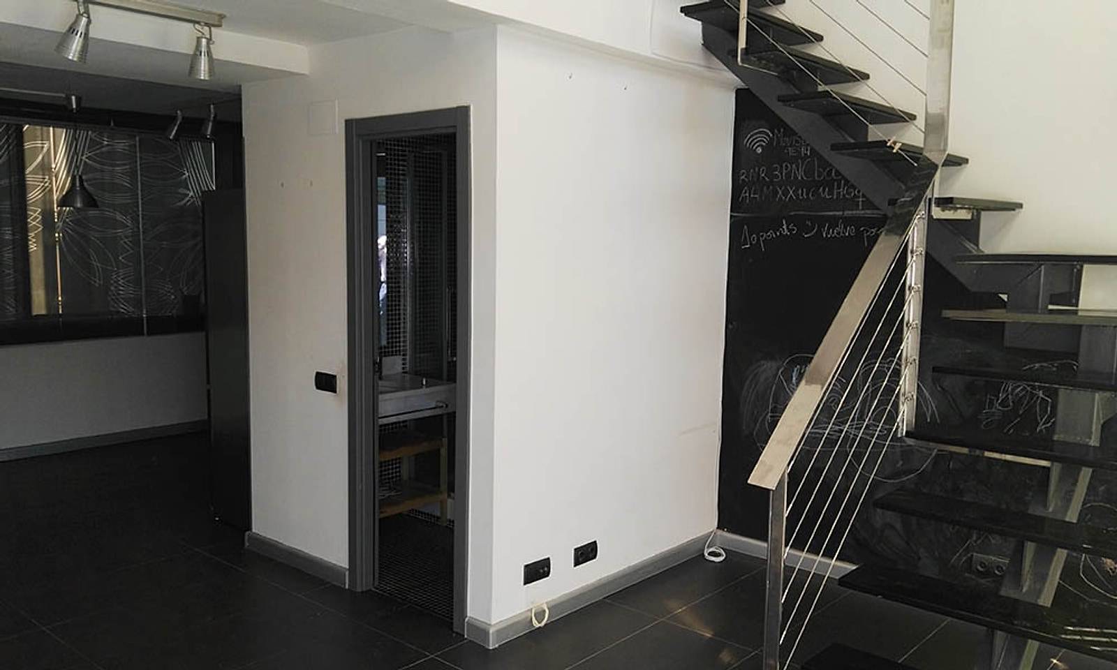 Escalera recta del loft antes de la reforma, junto a la puerta del baño