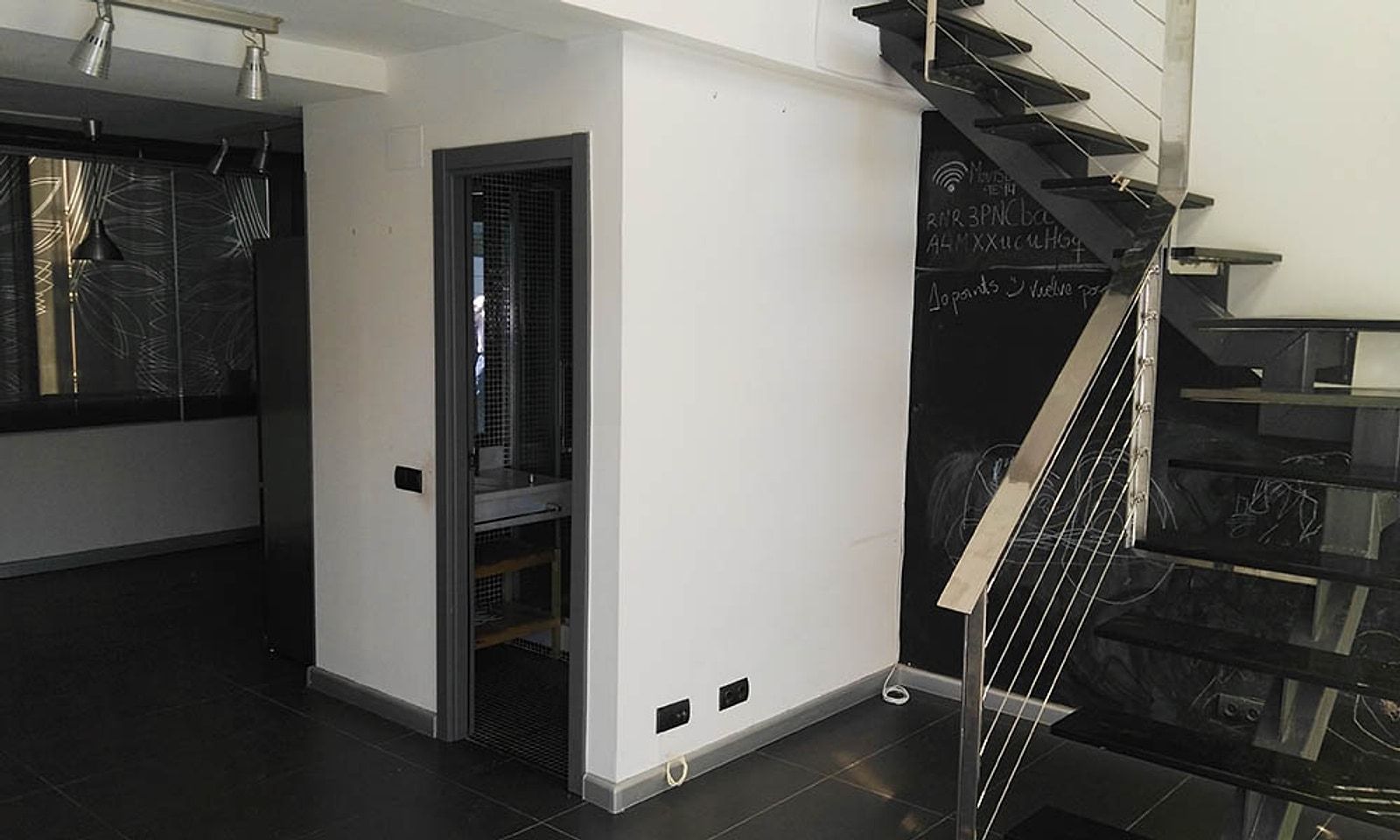 Escalera recta del loft antes de la reforma, junto a la puerta del baño