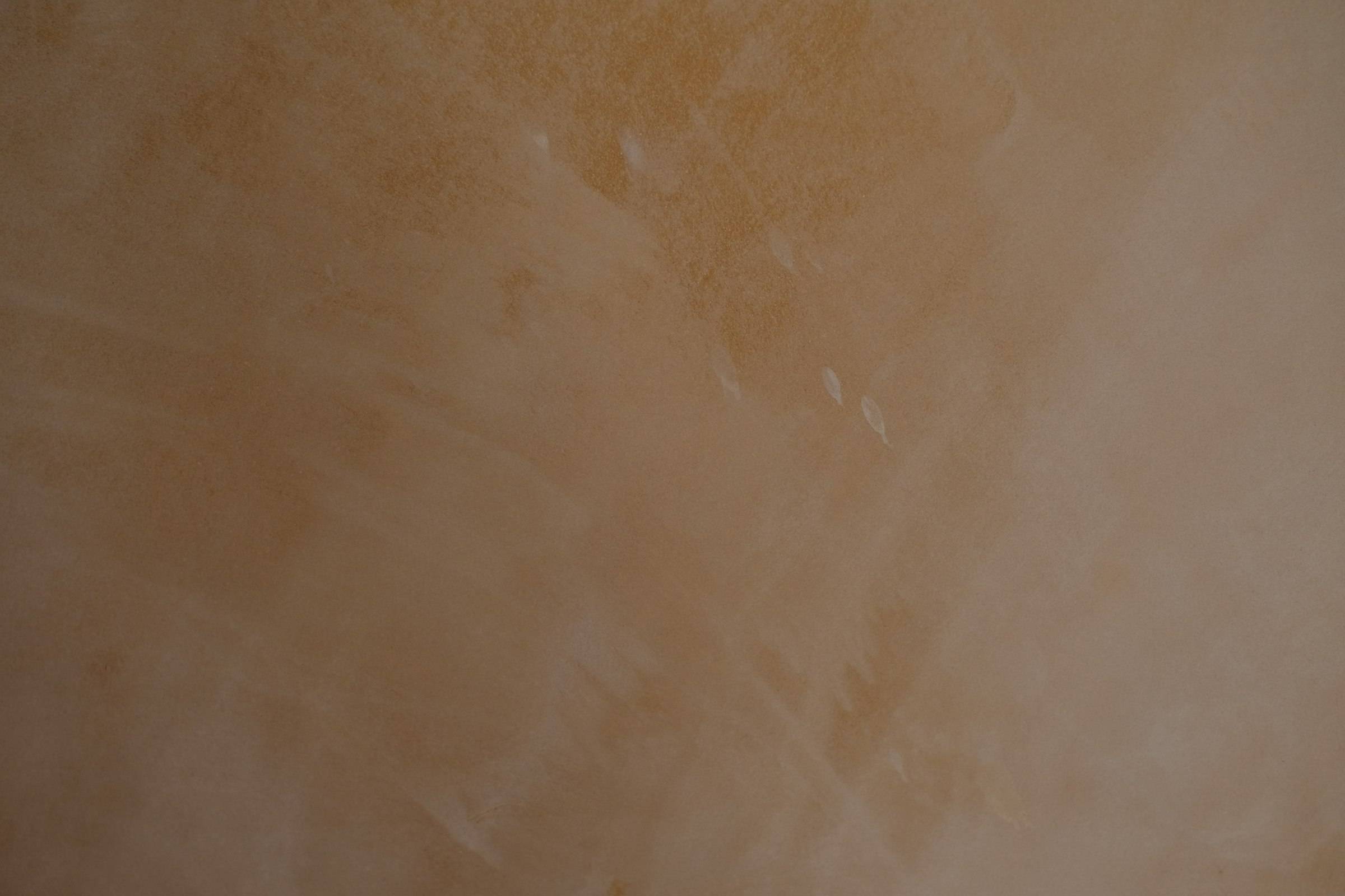 Pared con acabado de estuco veneciano liso en tonos tierra, con las vetas claras de la llana