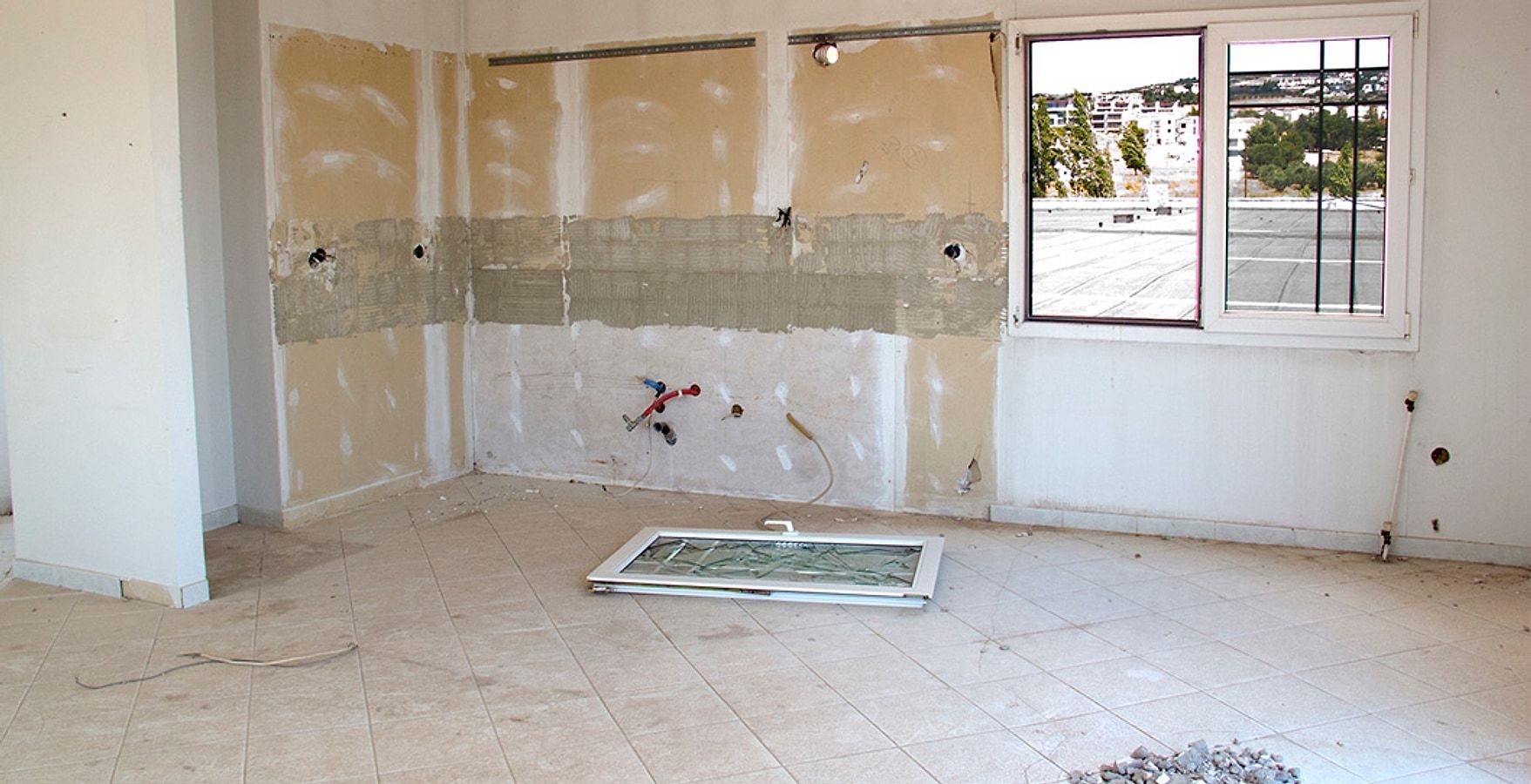 Cocina desmontada en obra, con las paredes picadas y la instalación a la vista