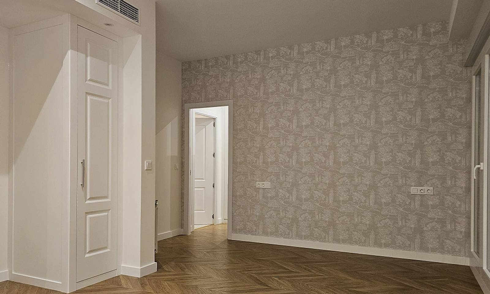 Recibidor reformado con armario empotrado blanco, papel pintado y suelo de madera en espiga