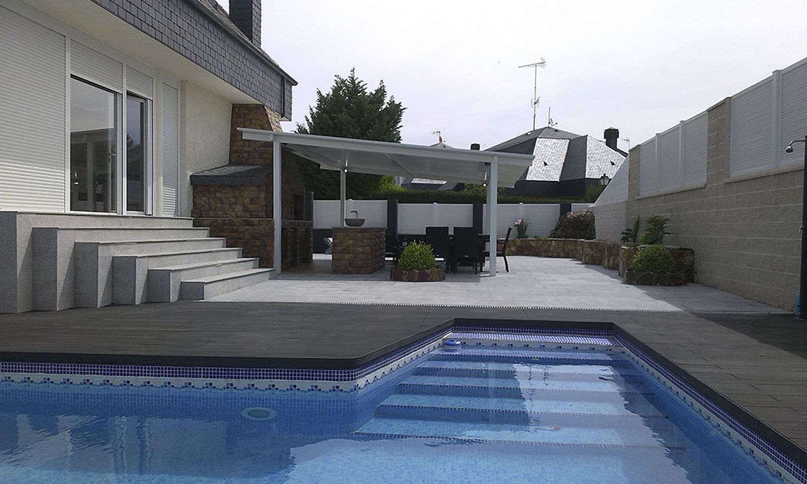 El mismo jardín reformado, con piscina, tarima, escalera de granito y porche