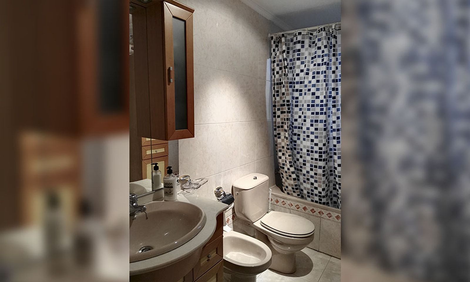 Baño antiguo con azulejo pequeño, cortina de ducha y lavabo de pie