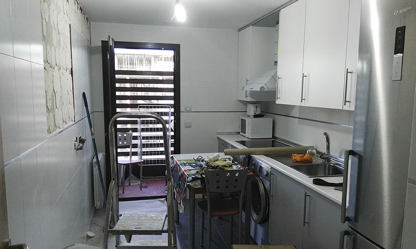 Cocina antigua a medio desmontar, con los azulejos picados