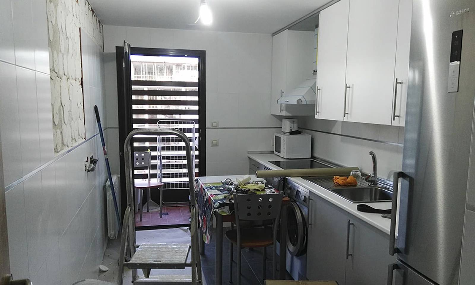 Cocina antigua a medio desmontar, con los azulejos picados