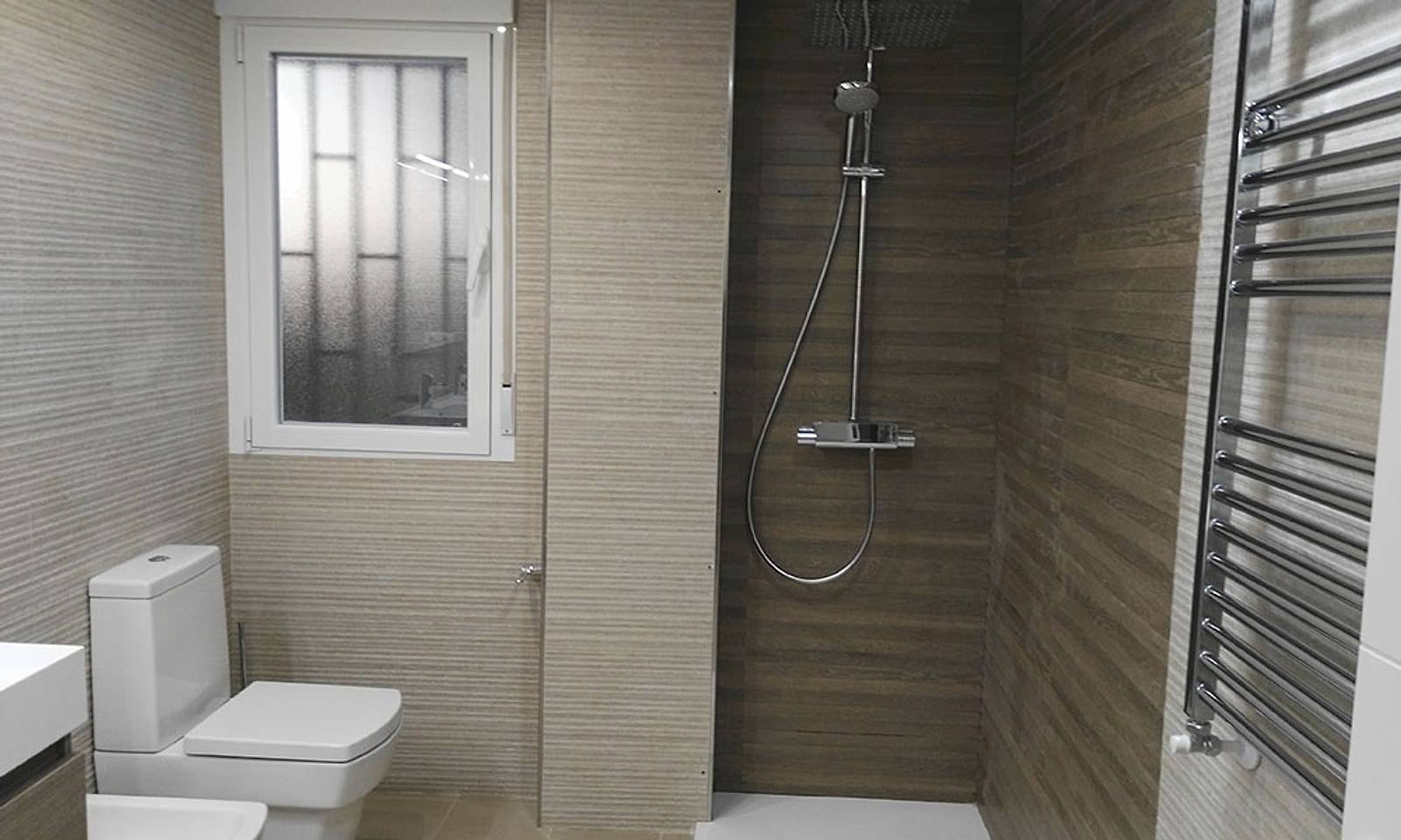 Baño con ducha, alicatado en tonos madera, inodoro y toallero