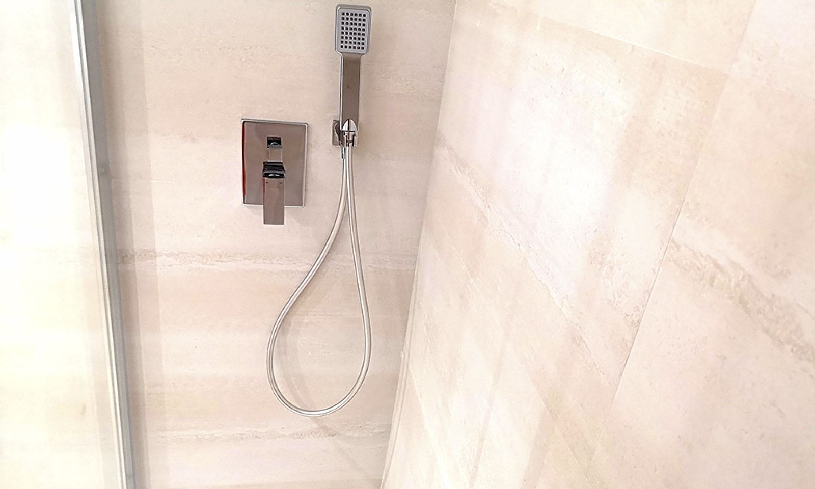 Ducha con grifería empotrada y alicatado de gran formato