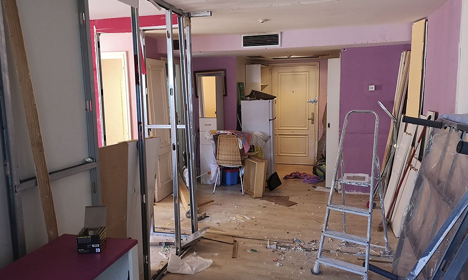 Entrada de un piso en obra, con tabiques a medio montar y escombro