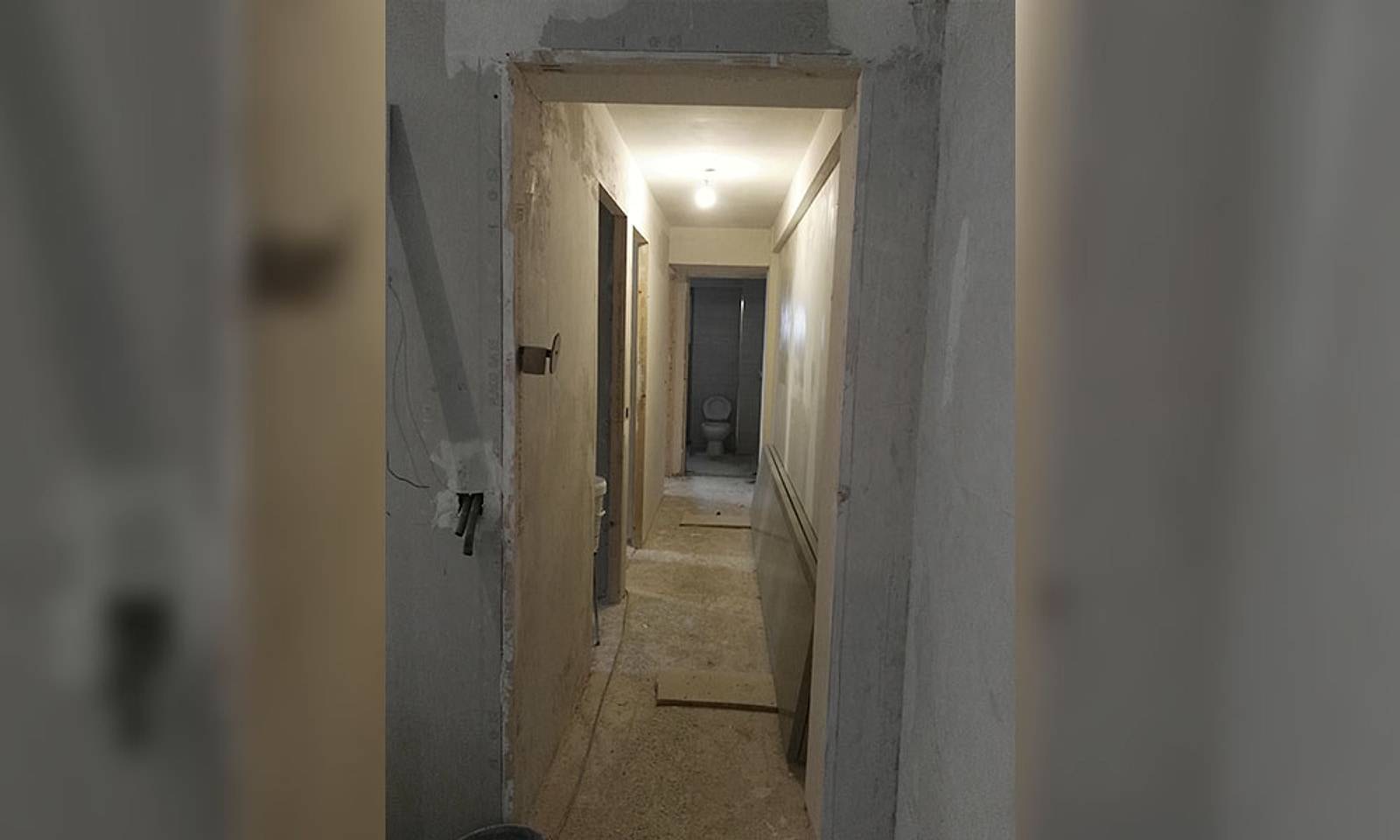 Pasillo de un piso en obra, con las paredes sin terminar