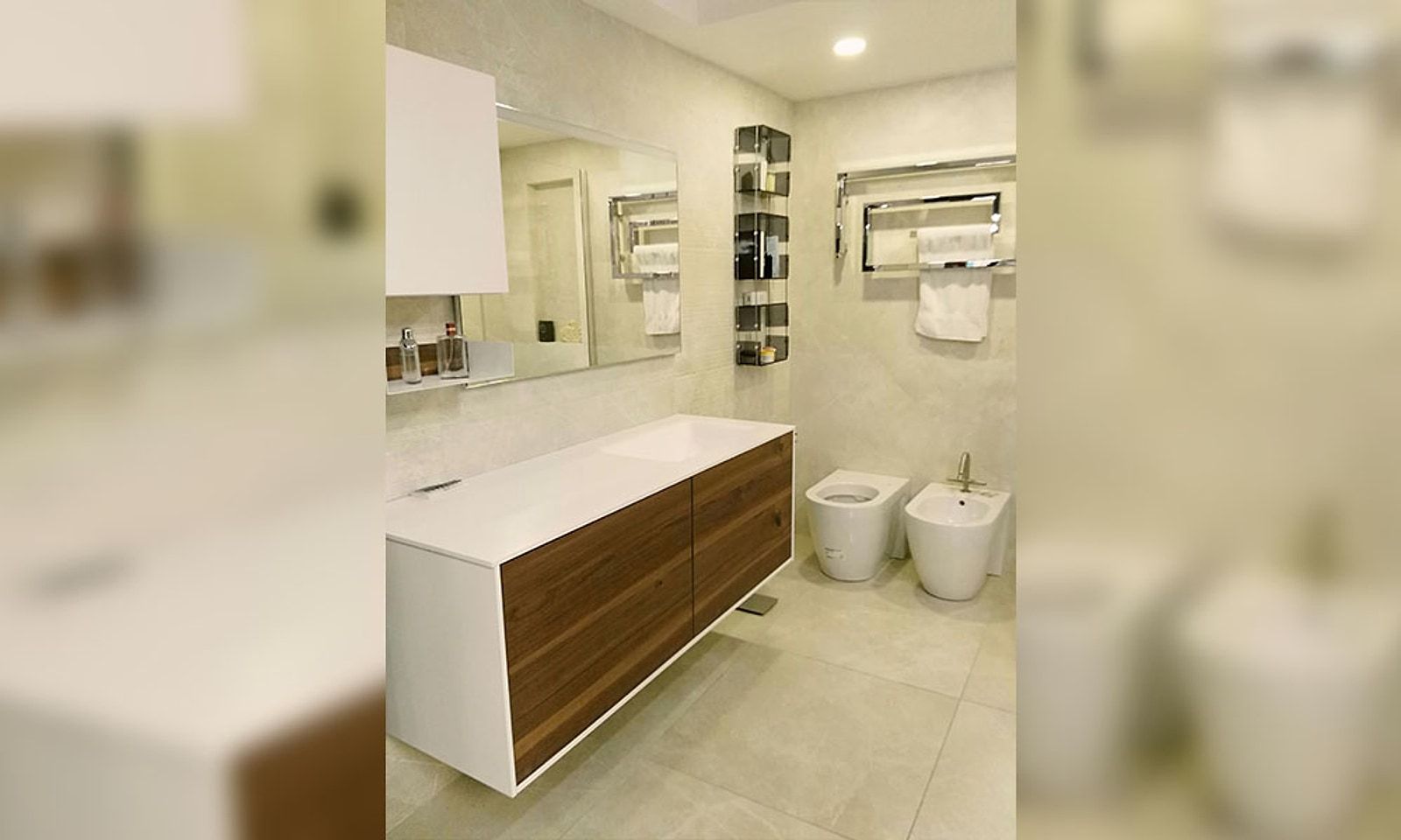 El mismo baño reformado, con mueble de lavabo wengué y blanco, bidé y alicatado claro