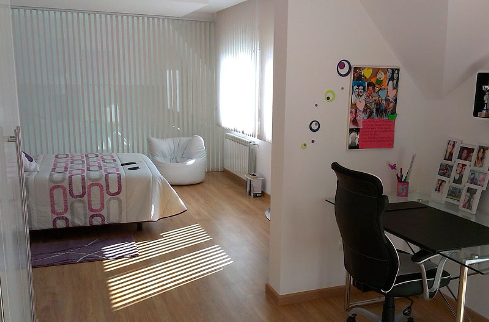 Dormitorio con zona de estudio y suelo de tarima