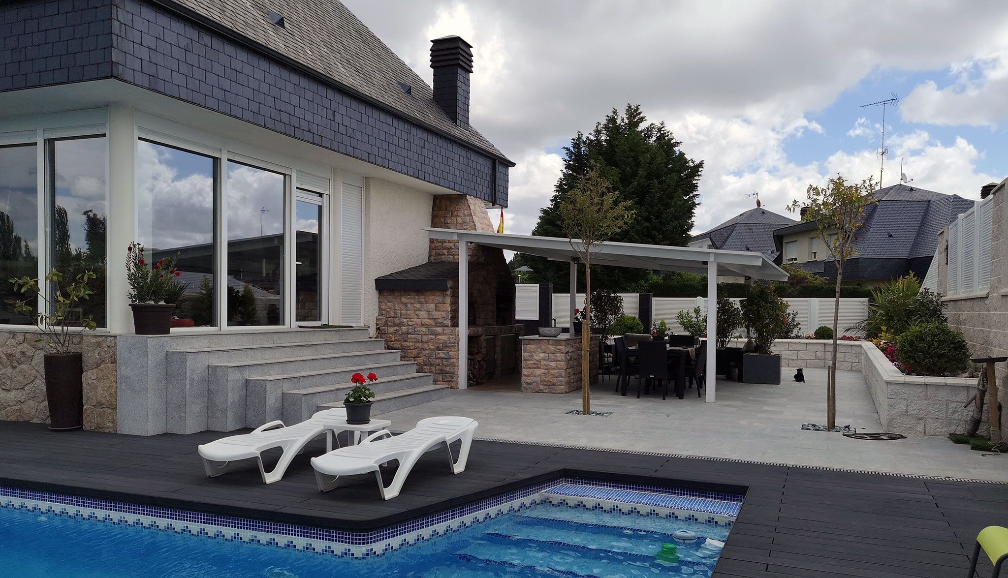 Piscina y porche en el jardín de un chalet