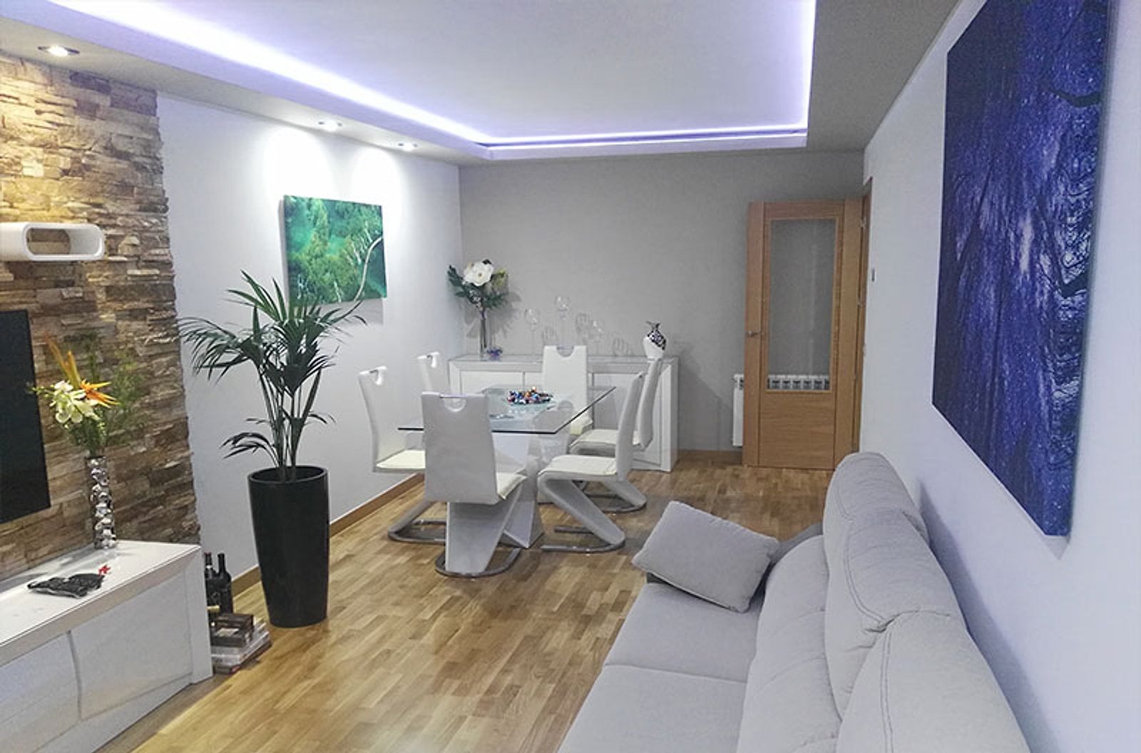 Salón comedor con techo de iluminación indirecta y suelo de madera