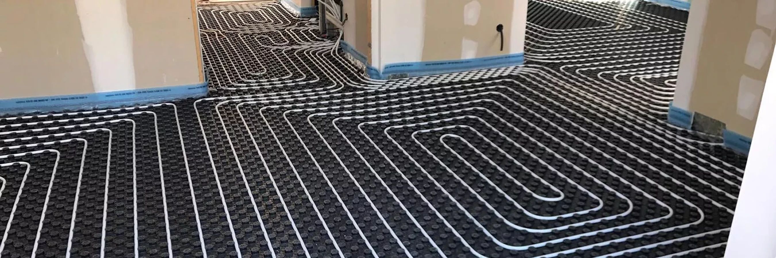 Tubos de suelo radiante sobre el panel aislante en una vivienda en obra