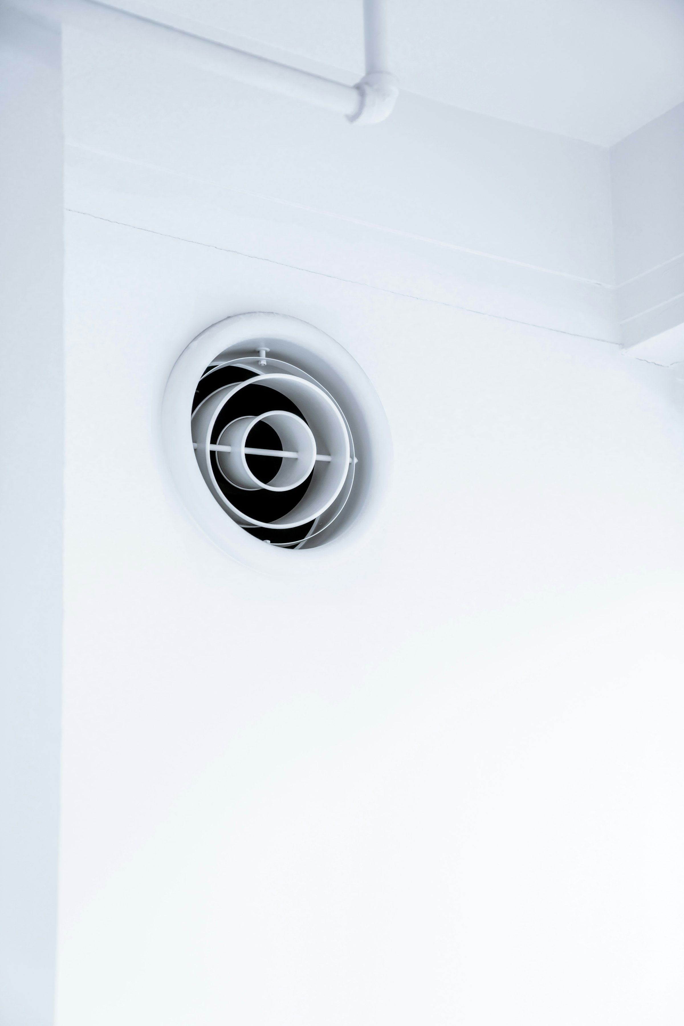 Rejilla redonda de ventilación en una pared blanca